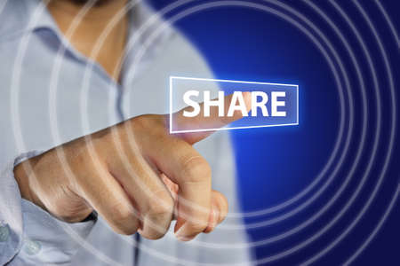 Image of a businessman pointing Share icon on virtual screen over blue backgroundの写真素材