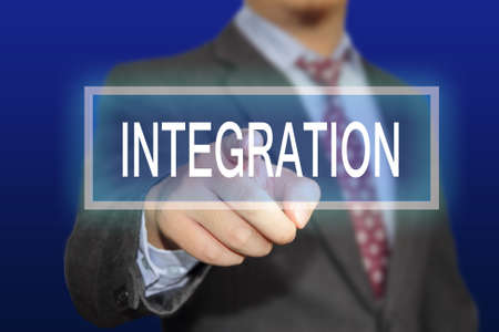 Business concept image of a businessman clicking Integration button on virtual screen over blue backgroundの写真素材