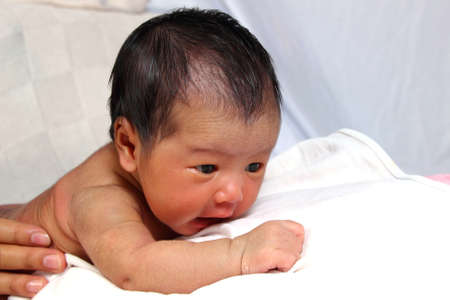 Naked newborn baby girl in face down positionの写真素材