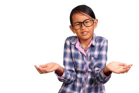 Little girl with glasses performing shrug or I don't know gesture isolated on whiteの写真素材