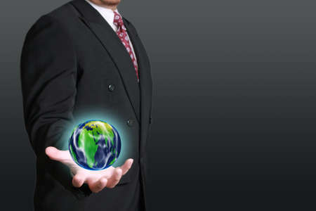 Business concept image of a businessman holding planet earth in his palmの写真素材
