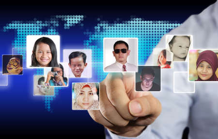 Internet Social Media Concept, image of a man clicking social media icons with people avatars in it over blue virtual screenの写真素材