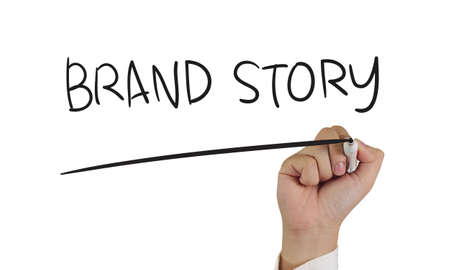 Business concept, image of a hand holding marker and write Brand Story, isolated on whiteの写真素材