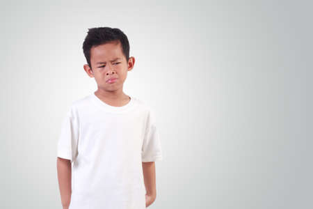 Portrait of Sad Asian boy with black hair wearing white shirt cryingの写真素材