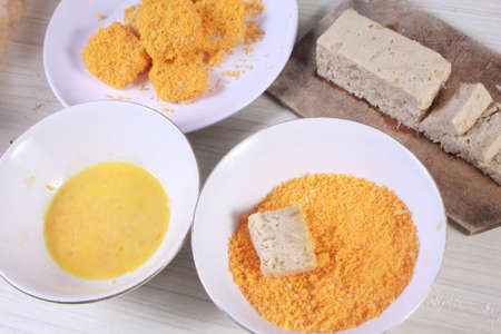 Close up image of homemade chicken nuggets with eggs and bread crumbsの写真素材