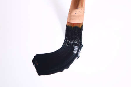Paint brush with black paint stroke isolated on white backgroundの写真素材