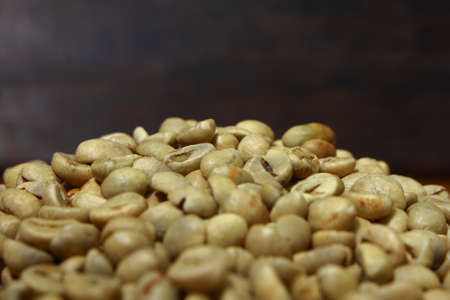 Pile of raw coffee beans with dark backgroundの写真素材