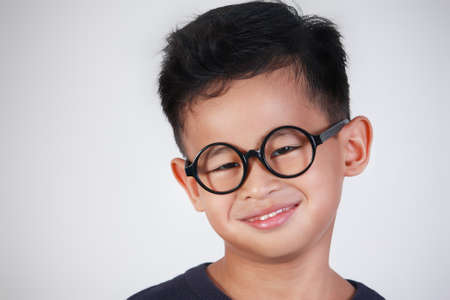 Portrait of little Asian boy wearing glasses smiling happilyの写真素材