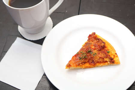 Top view slice of pizza and cup of morning coffee with blank paper templateの写真素材