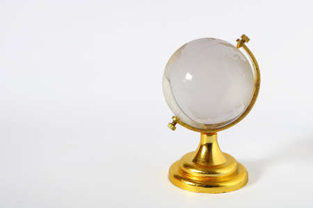 Photo image of glass earth globe with golden stand on white background with some empty spaceの写真素材