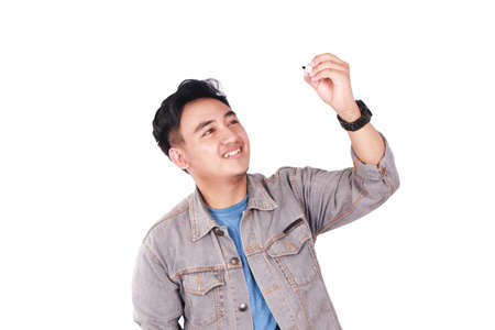 Photo image portrait of a cute young Asian male student standing and writing empty blackboard copyspace, isolated on whiteの写真素材