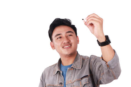 Photo image portrait of a cute young Asian male student standing and writing empty blackboard...