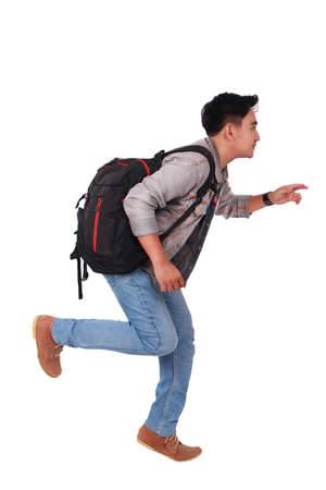 Photo image portrait of a young Asian male student running forward, side view, isolated on whiteの写真素材