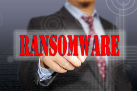 Hand of a businessman clicking Ransomware virus button on virtual screen