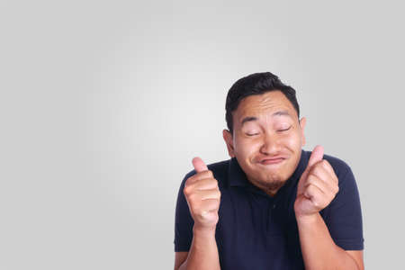Photo image of funny attractive cute Asian man smiling and showing thumb up signの写真素材
