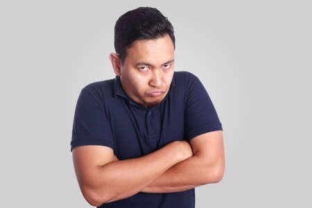 Photo image of funny Asian man showing synical unhappy angry facial expression