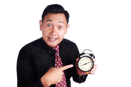 Portrait of angry businessman business manager boss showing alarm clock, mad of his too late employeeの写真素材