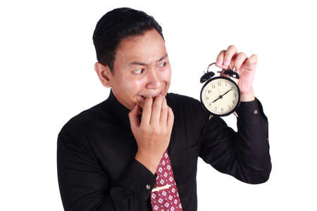 Portrait of young Asian businessman crying afraid of being late white holding clock on his hand