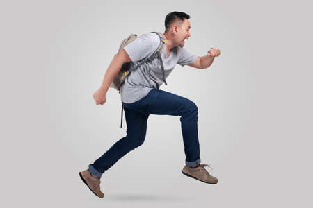 Attractive young Asian man worried and running fast to be lateの写真素材