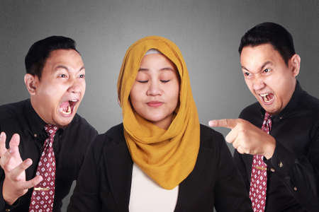 Portrait of muslim businesswoman close eyes and smile, keep calm under pressure of angry bossの写真素材
