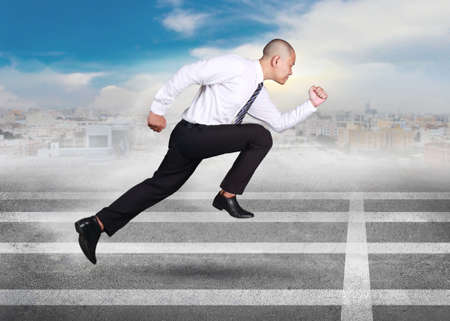 Portrait of young Asian businessman wearing black pants and white shirt running fast on track,...