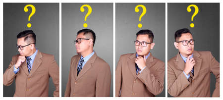 Business dilemma concept. Young Asian businessman getting confused with question mark symbol. Photo...