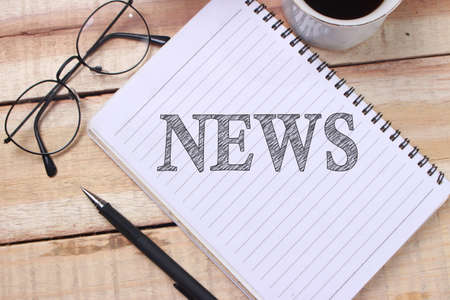 News words letter, written on notepad, work desk top view. Business typography concept