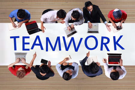 Teamwork in business concept. Top view of businessmen meeting on working desk in officeの写真素材