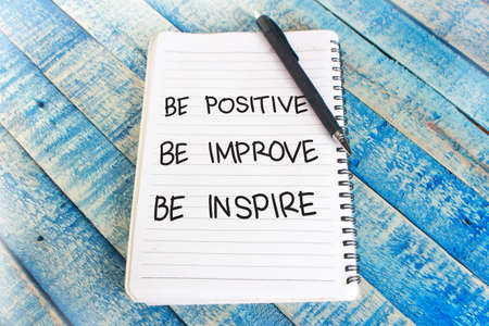 Be positive improve inspire words letter, written on notepad, work desk top view. Motivational business typography quotes conceptの写真素材
