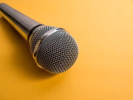 Microphone with copy space. Mic on orange background. Singing karaoke song conceptの写真素材