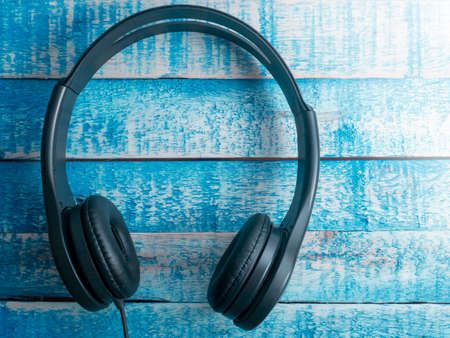Headphone. Earphones on blue wooden background. Music sound conceptの写真素材