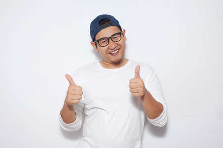 Photo image portrait of funny attractive cute young Asian man in white shirt smiling and showing...