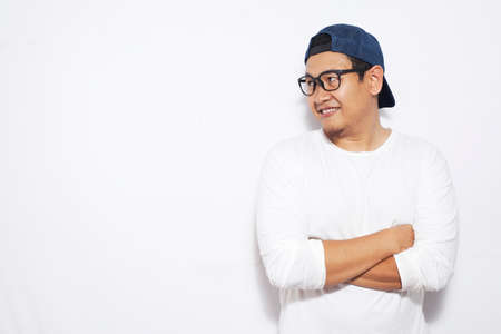 Photo image portrait of funny young attractive cute Asian man smiling happily, standing with crossed...