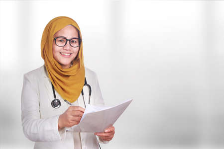 Portrait of happy smiling Asian muslim woman wearing hijab and suite. Confidence female doctor...