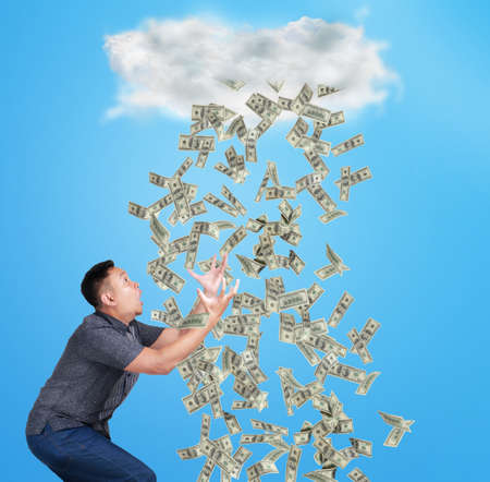 Portrait of happy successful young Asian billionaire man smiling happily under rain of money. Wealth...
