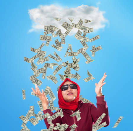 Portrait of happy successful young Asian billionaire woman smiling happily under rain of money....