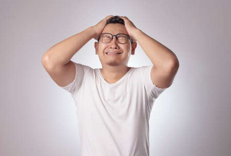 Photo image of funny Asian man crying close his eyes, sad depression frustration hopeless expressionの写真素材