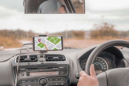 Car driver using smart phone with GPS map navigation while driving, car sharing app concept