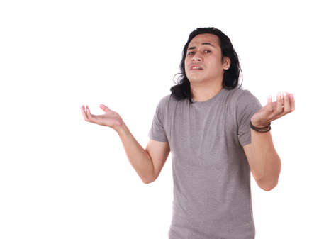 Portrait of funny young Asian man showing unhappy face, looking up with both of his palms open,...