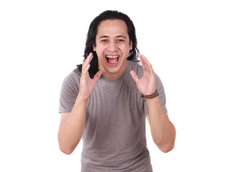 Portrait of young handsome long haired Asian man shouting hard isolated on white