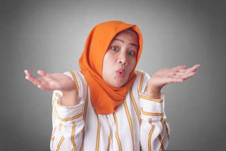 Portrait of Asian muslim businesswoman wearing hijab shows refusal or denial gesture, shoulder...