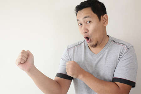 Photo image closeup portrait of a funny young Asian man dancing happily joyful expressing celebrating good news victory winning success gesture, smiling positive excited emotionの写真素材