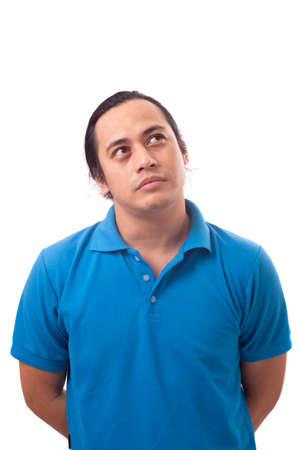 Young Asian man wearing casual blue shirt thinking, looking to the side. Close up body portrait isolated on whiteの写真素材