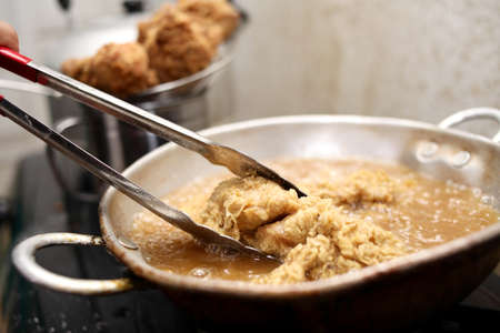 Close up image of cooking deep fry fried chicken, hot fat fryer in home kitchenの写真素材