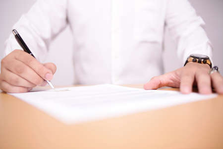 Close up image of businessman signing contract or student having exam test, selective focus