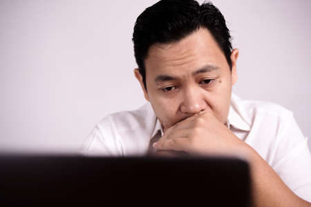 Portrait of Asian man Looked tired upset, depresssed and stressed looking at laptop, sleepy tired stress gesture, bad business pressure, work addict conceptの写真素材