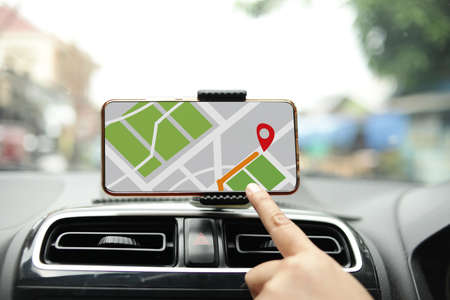 Car driver using smart phone with GPS map navigation while driving, car sharing app concept