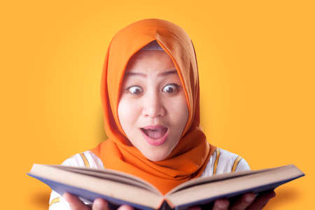 Portrait of young muslim businesswoman wearing hijab reading bookの写真素材