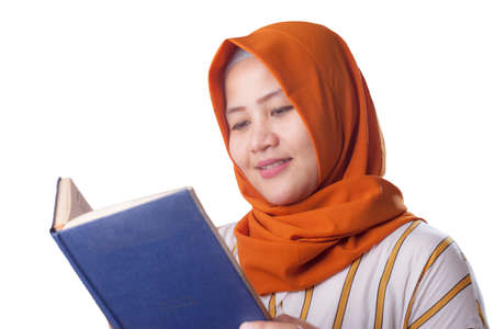 Portrait of young muslim businesswoman wearing hijab reading book, isolated on whiteの写真素材