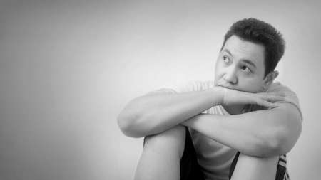 Photo image of sad young Asian man, tired and sleepy, thinking up expression, black and white...